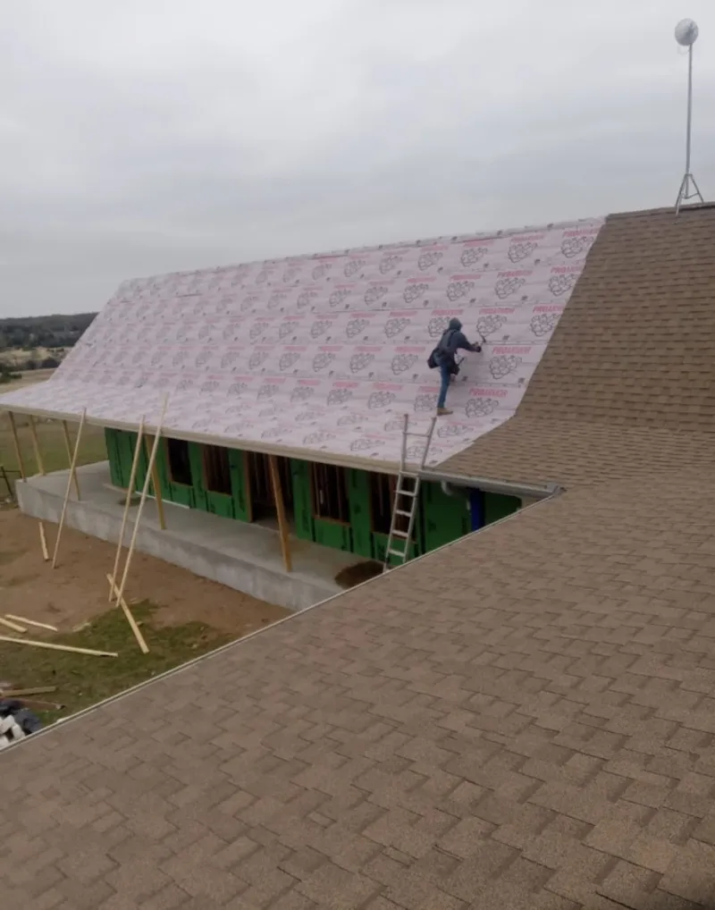Worker preparing underlayment for a metal roof installation in Moab
